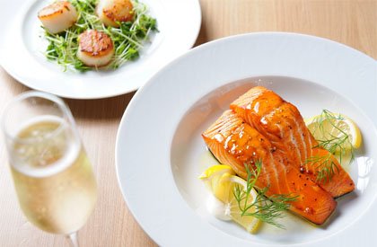 Блюдо из лосося и бокал шампанского на столе