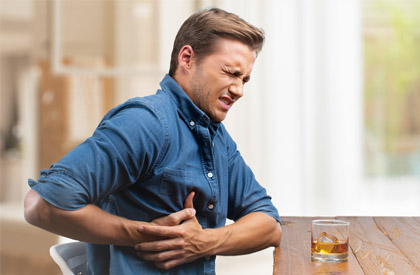 Гептрал при алкоголизме — человек держится за живот от боли